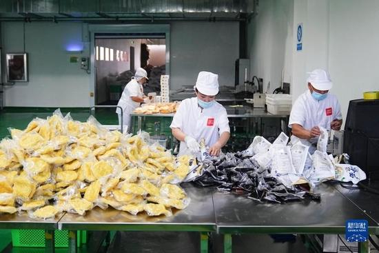 6月8日,工人在吉林省梅河口市大长今食品加工车间内打包产品.
