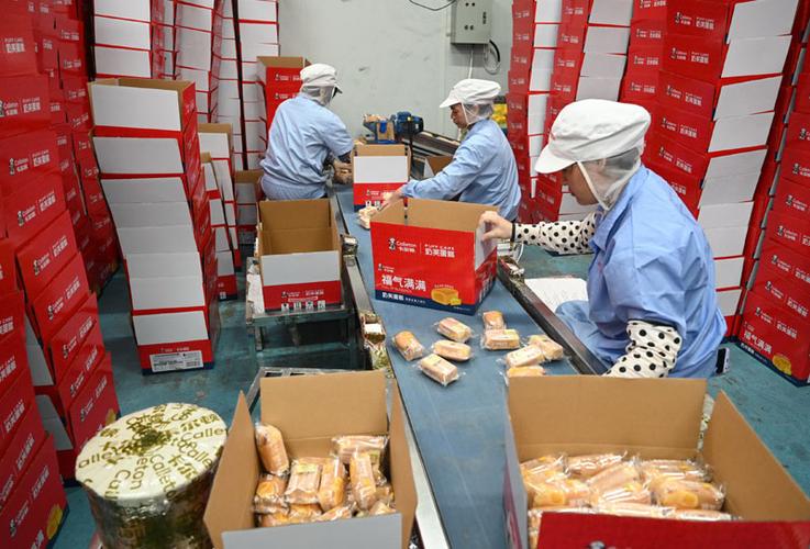 11月19日,工人在位于福建龙海的一家食品公司车间包装蛋糕产品.